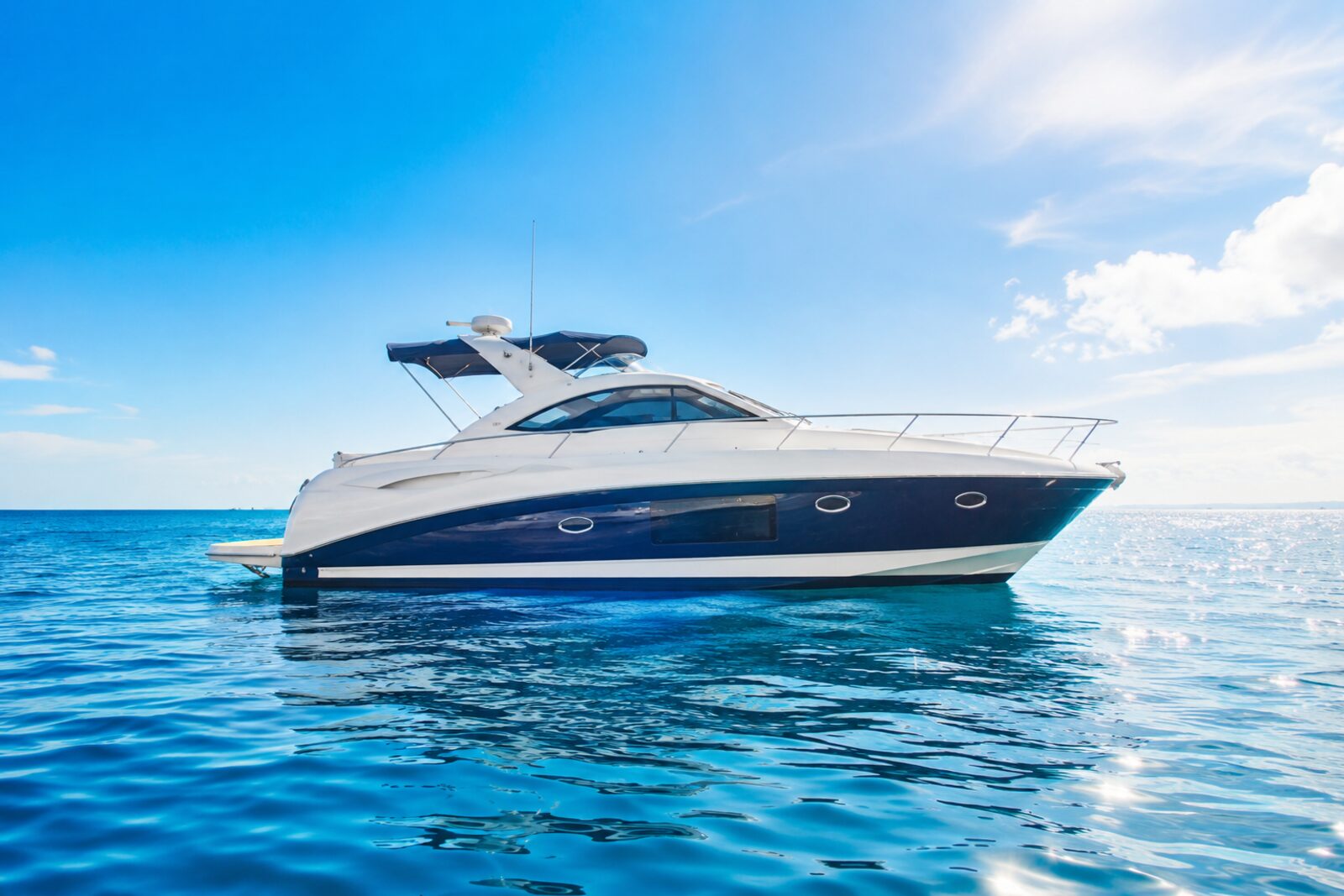 Modern motor yacht on calm blue open water under a clear sky